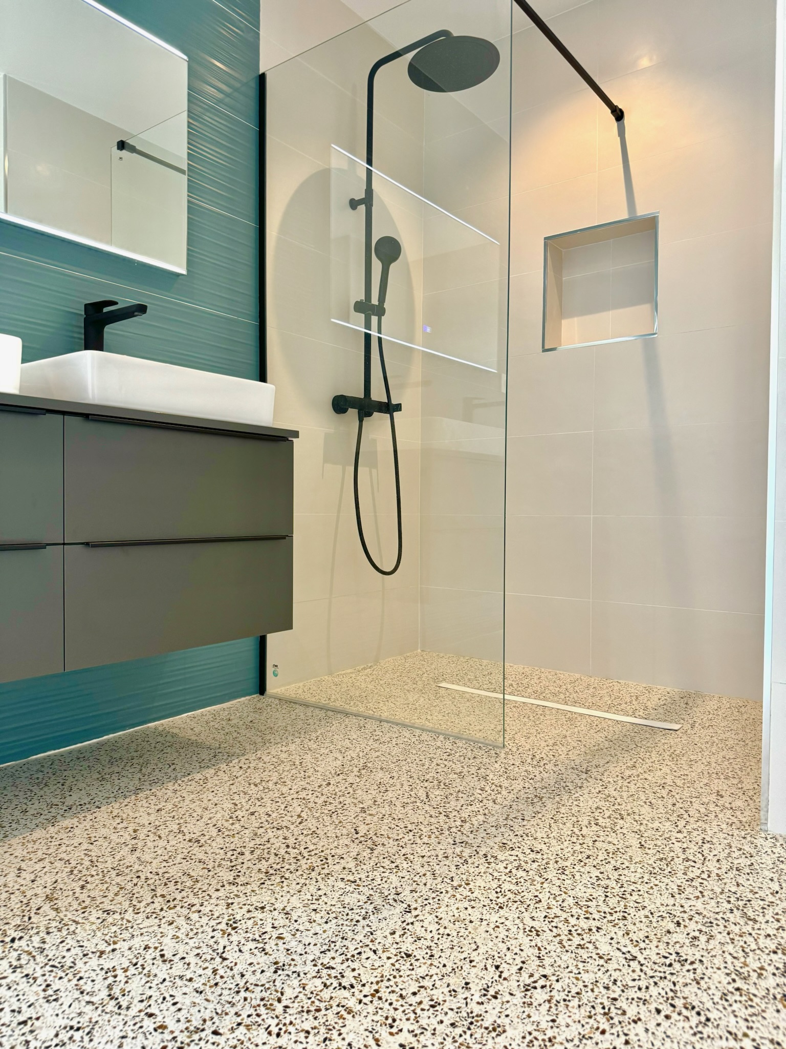 Terrazo continuo crema en baño con ducha a ras