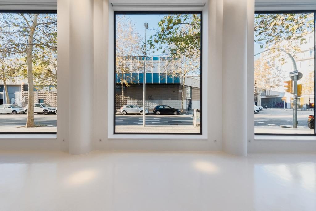 Sala diáfana con pavimento DECOPOX continuo frente a grandes ventanales