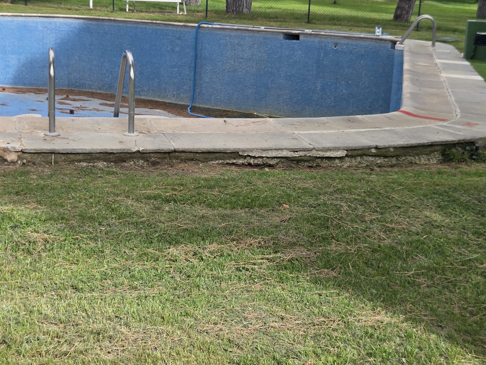 Detalle del deterioro del revestimiento y el rodapié de una piscina