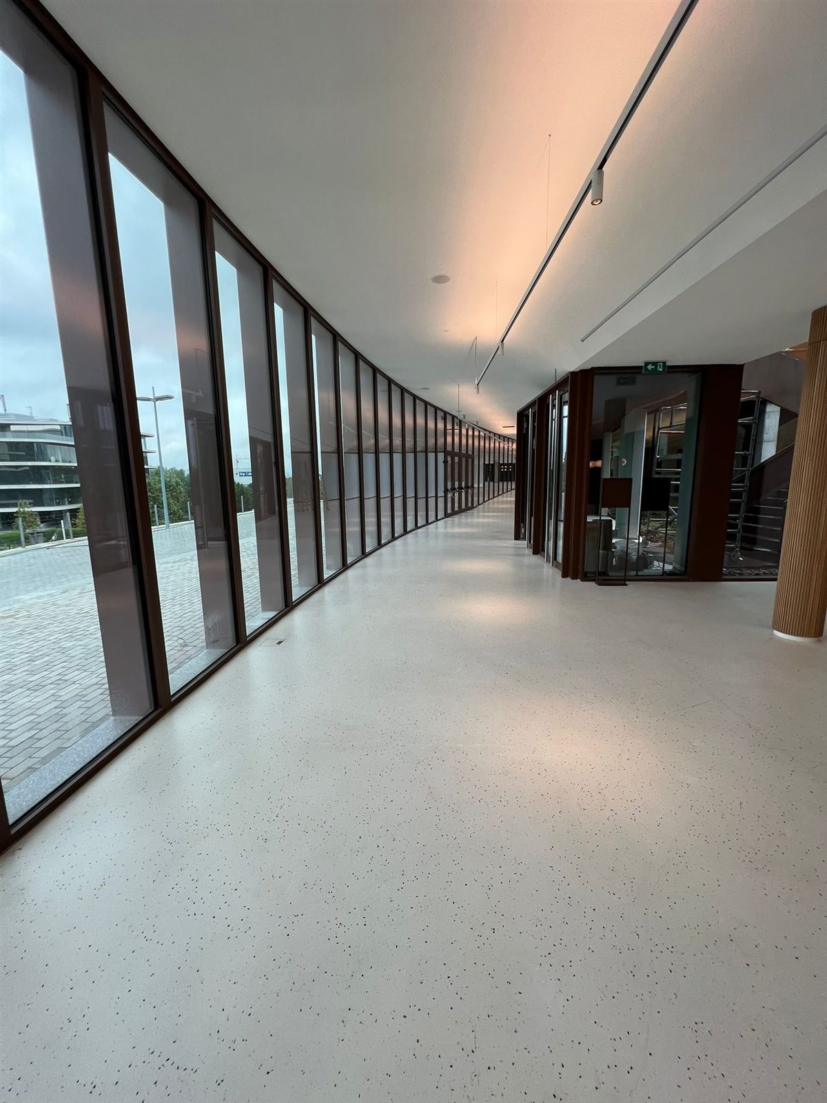 Lobby con terrazo continuo Stone Feel y columnas de madera