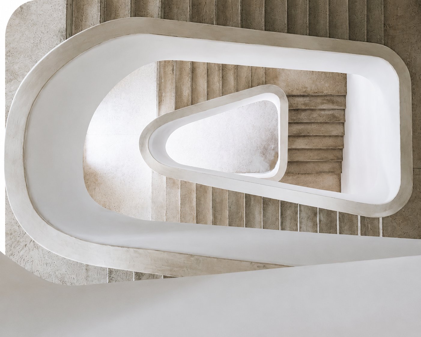 Vista cenital de escalera en espiral con pavimento de piedra y barandilla blanca