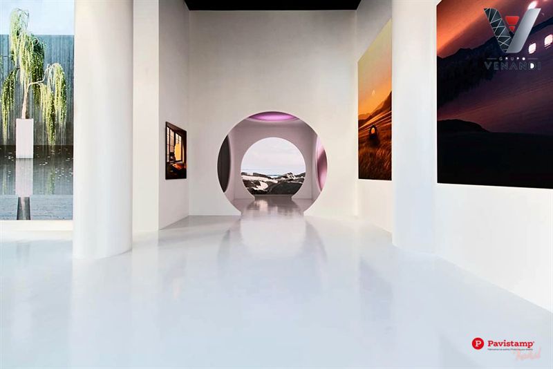Espacio expositivo blanco con suelo Decopox de alto brillo y arco circular