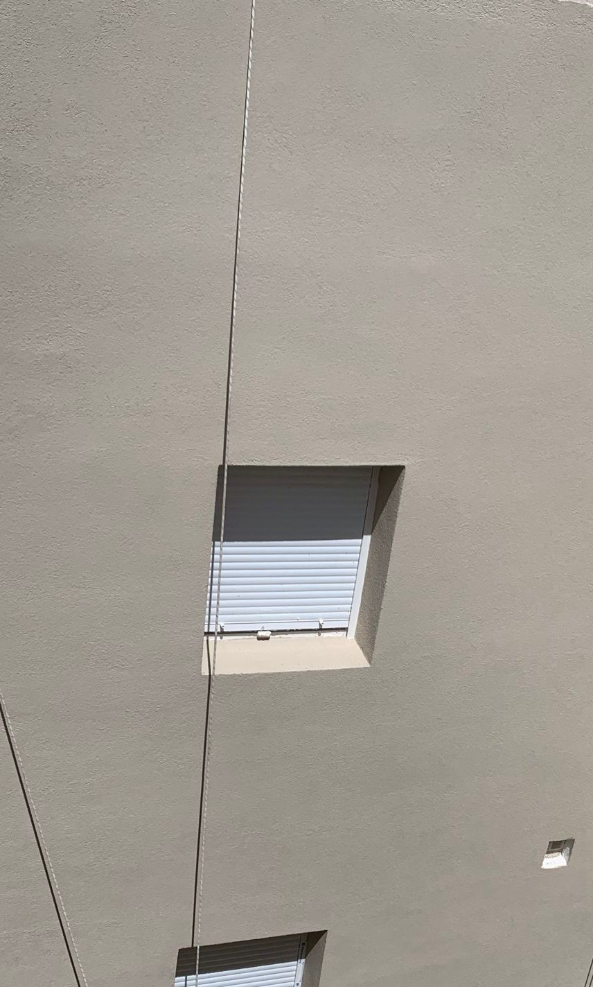 Acabado acrílico en fachada gris SATE en Casería Aguirre Granada — detalle de ventanas